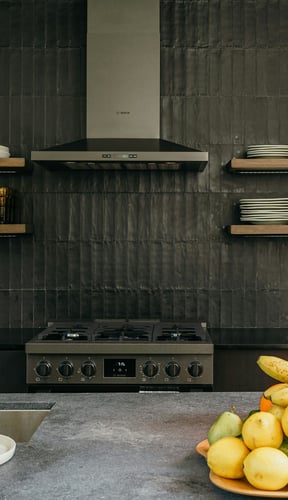 Dark kitchen with open shelves, Bosch range, and fruit bowl on concrete counter